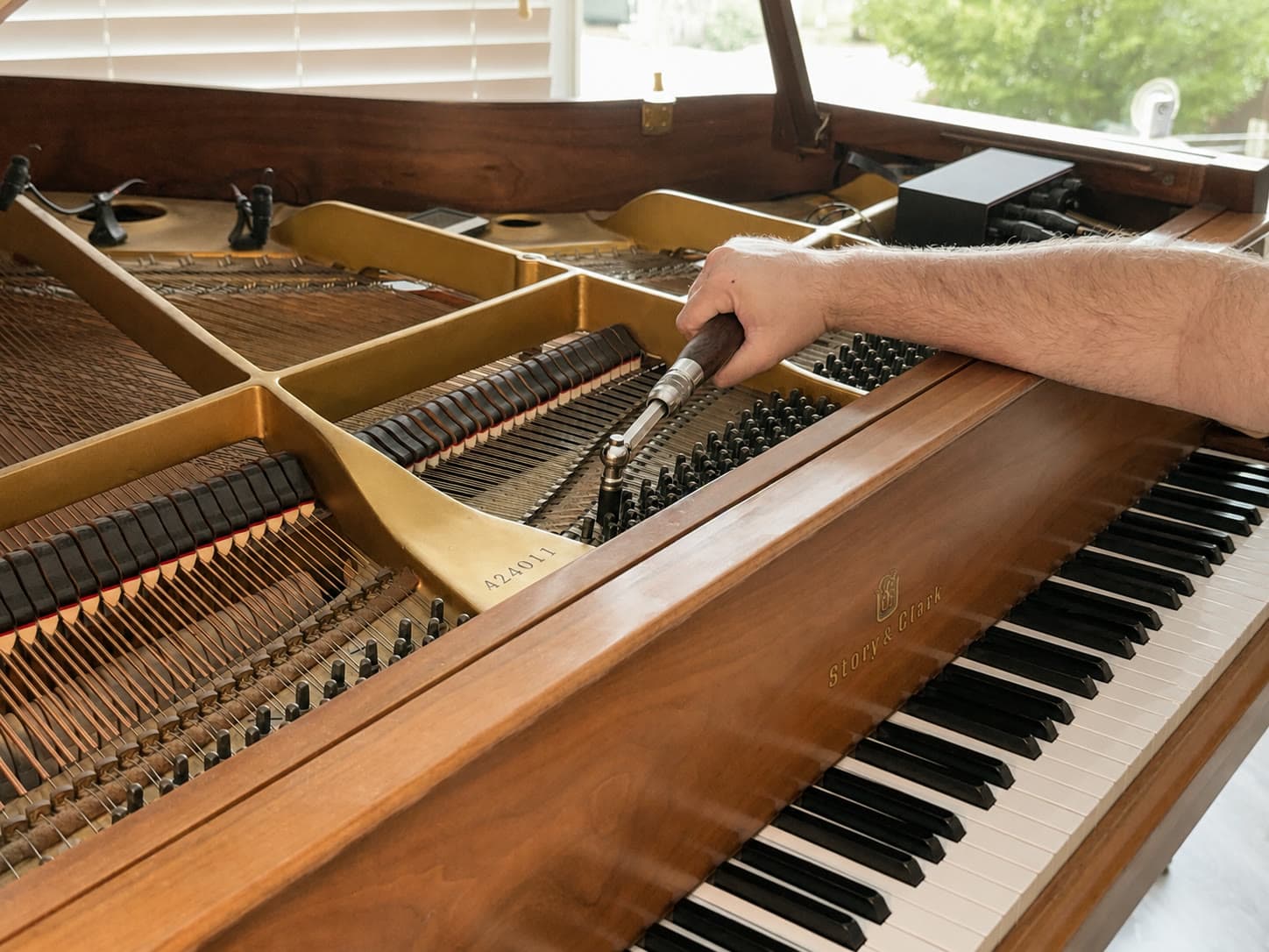 Setting a tuning pin with a lever on the pinblock of a Story & Clark grand